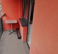 Ein Balkon mit roten Wänden in einer 2-Zimmer-Wohnung in der Nábrežná-Straße in Vrútky.