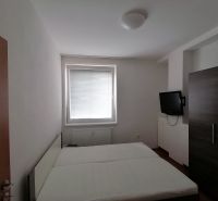 Schlafzimmer in einer 2-Zimmer-Wohnung mit Fernseher und Bett.
