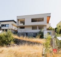 Ein Einfamilienhaus in der Komenského-Straße in Banská Bystrica mit einem ungepflegten Garten und einem Gewächshaus.