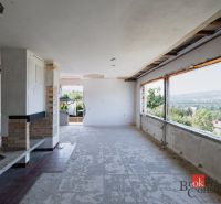 Innenraum eines renovierten Zimmers mit großen Fenstern in einem Einfamilienhaus.