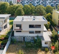 Ein Einfamilienhaus in der Komenského-Straße in Banská Bystrica, umgeben von weiteren Gebäuden und Grünflächen.