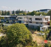 Ein Einfamilienhaus in der Komenského-Straße in Banská Bystrica, umgeben von Grünflächen und weiteren Gebäuden.