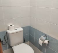 Badezimmer mit hellen Fliesen und Toilette in einer 2-Zimmer-Wohnung.