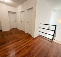 Innenraum eines Einfamilienhauses mit Holzdekorboden und weißen Türen.