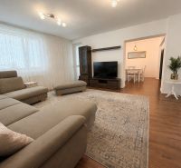 Helles Wohnzimmer mit Ecksofa und Holzboden in einem Einfamilienhaus.