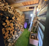 Holzinterieur der Hütte mit einem Vorrat an Holz und Werkzeugen.