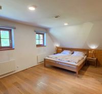 Ein Zimmer in einer Hütte mit Holzboden und einem Doppelbett.