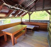 Außenbereich der Hütte in Jarabá mit einem Holzunterstand und Sitzgelegenheiten.
