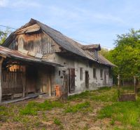 Ein älteres Einfamilienhaus in der Gemeinde Čelovce, umgeben von Grünflächen und Holzanbauten.