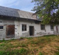 Ein Einfamilienhaus in Čelovce mit abgenutztem Putz, Holztüren und einem Garten.