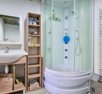 Ein Badezimmer in einem Einfamilienhaus mit einer Eckdusche und einem Waschbecken.