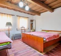 Ein Schlafzimmer in einem Einfamilienhaus mit einer Holzdecke und bequemen Betten.