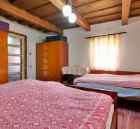 Schlafzimmer in einem Einfamilienhaus mit Holzdecke, Schränken und Leuchte.