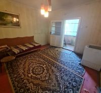 Ein Zimmer in einem Einfamilienhaus mit Teppichen, Beleuchtung und einem Sofa.