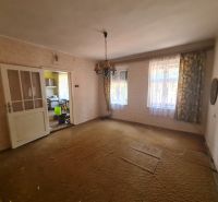 Wohnzimmer in einem Einfamilienhaus mit Teppichboden und antikem Kronleuchter.