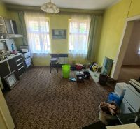 Wohnzimmer mit Teppichdekor, Möbeln und Plastikeimern in einem Einfamilienhaus.