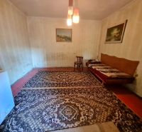 Ein Zimmer in einem Einfamilienhaus mit Teppich, Stuhl und Sofa.