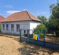 Ein Einfamilienhaus in Dolné Otrokovce mit einem Zaun und einem Garten auf einem sonnigen Grundstück.
