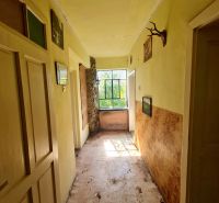 Der Flur in einem Einfamilienhaus mit einem Fenster am Ende und Dekorationen an den Wänden.