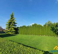 Ein ruhiger Garten, umgeben von Bäumen in Dolný Štál, geeignet für Wohnbaugrundstücke.