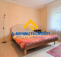 Ein Schlafzimmer in einem Einfamilienhaus mit rotem Teppich und großem Fenster.