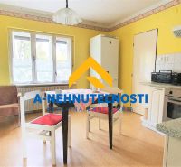 Küche in einem Einfamilienhaus mit Holzboden und gelben Wänden.