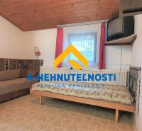 Ein Zimmer in einem Einfamilienhaus mit einem Sofa, einem Bett und einem Fernseher an der Wand.