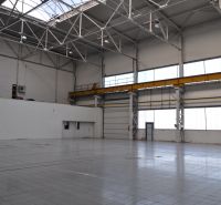 Produktionsräume mit hoher Decke, Fenstern und Betonboden.