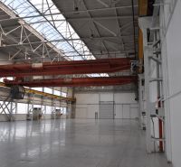 Industriehalle in Produktionsräumen mit zwei Kränen und verglastem Dach.