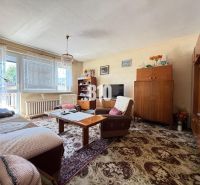 Wohnzimmer in einem Einfamilienhaus mit Holzmöbeln und dekorativem Teppich.