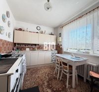 Eine Küche in einem Einfamilienhaus mit Sitzgelegenheiten, Kacheln und dekorativen Tellern an der Wand.