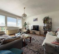 Wohnzimmer in einem Einfamilienhaus mit großen Fenstern, Holzboden und bequemen Sitzgelegenheiten.