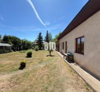 Ein Einfamilienhaus in Kláštor pod Znievom mit Garten und Gewächshaus an einem sonnigen Tag.