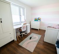 Kinderzimmer mit weißen Möbeln und Holzboden in einem Einfamilienhaus.