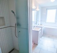 Badezimmer in einem Einfamilienhaus mit Badewanne, Dusche und Waschbecken.