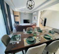 Esszimmer in einem Einfamilienhaus mit eleganter dunkler Ausstattung und sechs Stühlen.