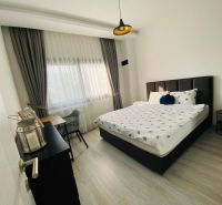 Schlafzimmer mit Bett, Schreibtisch und Holzboden in einem Einfamilienhaus.