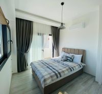 Schlafzimmer mit großem Fenster, Vorhängen und Holzboden in einem Einfamilienhaus.