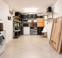 Der Hauswirtschaftsraum in der Vierzimmerwohnung enthält eine Waschmaschine, eine Mikrowelle und Lagerregale.
