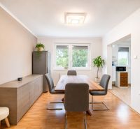 Esszimmer in einer 4-Zimmer-Wohnung mit Holzboden und einer Pflanze.