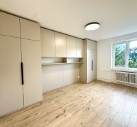 Ein Zimmer in einer 3-Zimmer-Wohnung mit geräumigen Schränken und einem Boden in Holzoptik.