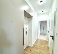 Der Flur in der 3-Zimmer-Wohnung mit Holzboden und weißen Wänden.