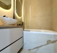 Badezimmer mit Waschbecken auf einem Schrank und Badewanne in einer 3-Zimmer-Wohnung.