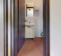 Waschbecken mit Keramikschrank in Geschäftsräumen, Raum mit weißen Wänden.