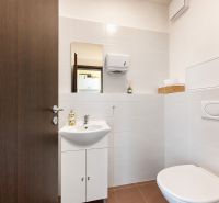 Toiletteneinrichtung in Geschäftsräumen, weiße Keramik, einfache Ausstattung.