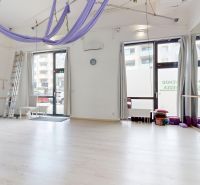 Geschäftsräume mit Holzboden, ausgestattet mit Spiegeln und Trainingsgeräten.