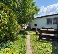Der Garten eines Einfamilienhauses in Bratislava - Ružinov in der Senná-Straße mit einer Holzsitzgelegenheit.