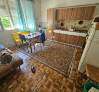Küche in einem Einfamilienhaus mit Esstisch, Küchenzeile und Boden in Holzoptik.