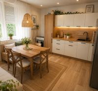 Küche in einem Einfamilienhaus mit Esstisch und Boden in Holzoptik.