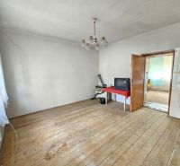 Ein Zimmer in einem Einfamilienhaus mit einem Holzboden, ein Fernseher auf einem Tisch.